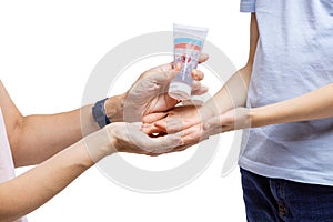 Closeup view of woman applying hand-sanitizer anti-bacterial gel on son`s hands