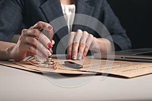 Closeup view of woman attorney writing on documents by pen.