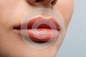 Closeup view of woman with beautiful lips on light background