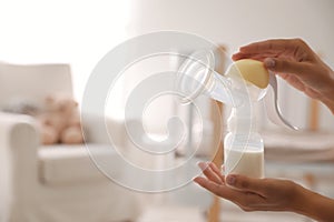 Closeup view of woman holding manual breast pump, space for text. Baby health