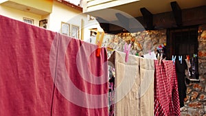Closeup view of a woman taking off clean and dry laundry from the clothesline outdoors