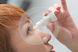 Closeup view of young asian woman applying eye drop. artificial tears
