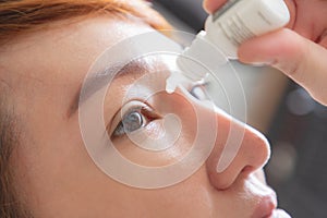 Closeup view of young asian woman applying eye drop. artificial tears