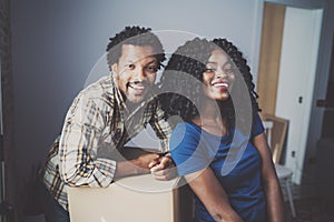 Closeup view of young black african man and his girlfriend moving boxes into new house together and making a successful