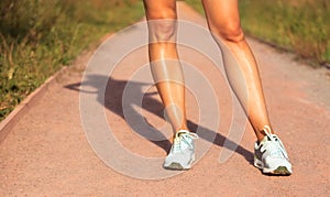 Closeup view of young female legs in sports shoes outdoors. Sport and fitness concept