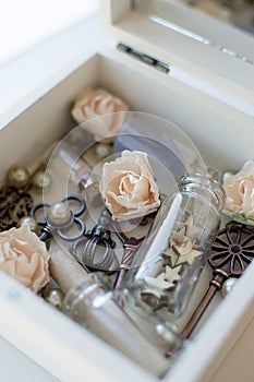 Closeup vintage casket of secrets with mirror, flowers, keys and small glass jars