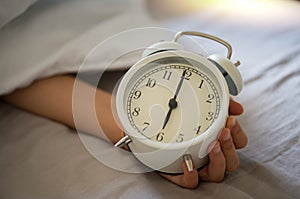 Closeup vintage clock in a boy hand showing 6am 6 oclock in the morning. photo