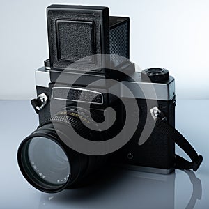 A closeup of a vintage medium format film camera against white background