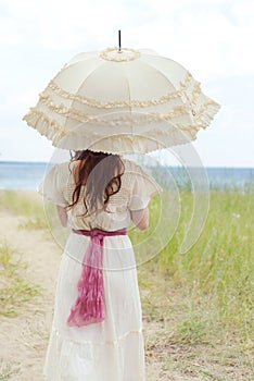 Closeup vintage woman with parasol at the beach