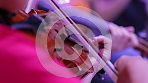 Closeup of a violin and hand with a bow. Symphony Orchestra. Violinists' performing. Classical music