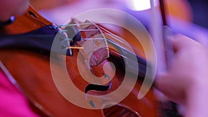 Closeup of a violin and hand with a bow. Symphony Orchestra. Violinists' performing. Classical music