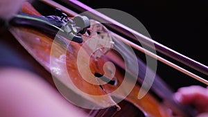 Closeup of a violin and hand with a bow. Symphony Orchestra. Violinists' performing. Classical music