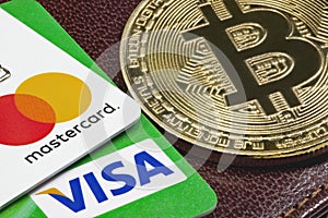 Closeup of Visa, Mastercard credit cards and golden bitcoin