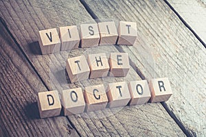 Closeup Of A Visit The Doctor Reminder Formed By Wooden Blocks On A Wooden Floo