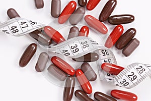 Closeup of vitamin and supplement pills with measured tape..