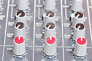 Closeup on volumes of sound mixing console in audio recording st