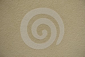 Closeup of wall with light beige roughcast finish photo