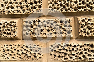 Closeup wall sandstone bricks holes decoration background