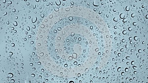 Closeup of water droplets on a glass, during the rain. Large raindrops fall on a window pane 4K.