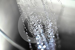 Closeup of water drops falling from the shower head in the bathroom