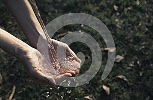 Closeup water flow to hand of women for nature concept on the garden background