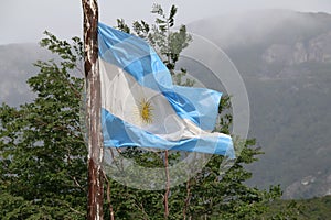 Closeup of a waving flag of Argentina against a natural landscape background