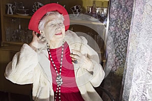 Closeup of a wealthy senior woman wearing necklace against black background