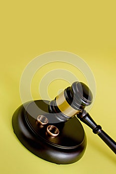 Closeup of wedding rings on wooden mallet at table in courtroom