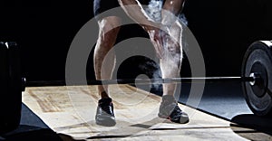 Closeup of weightlifter clapping hands before barbell workout at