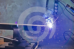 Closeup of Welding Process With Sparks of Professional Male Welder During Welding Process of Metal Rod At Factory