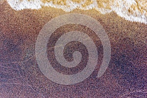 Closeup of wet colorfull sand pattern of a beach