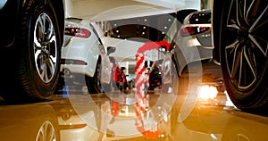 Closeup wheel of car parked in modern showroom. Rear view of luxury SUV car. Car dealership office. Automobile retail shop.