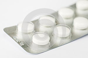 Closeup white antibiotics capsule pills in blister pack. Pharmacy background.