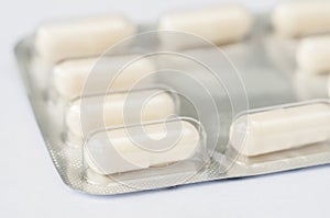 Closeup white antibiotics capsule pills in blister pack. Pharmacy background. Antimicrobial drug resistance. Pharmaceutical