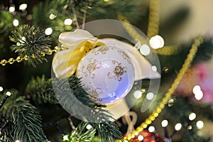 Closeup white ball hanging on merry christmas tree. New year toy at pine tree