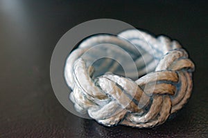 Closeup of a white and blue ring from a string in a knotted design