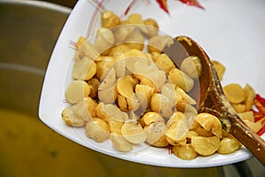 Closeup white bowl of cooked olluco with wooden photo