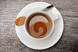 Closeup white ceramic cup of hot Turmeric tea with tumeric powder