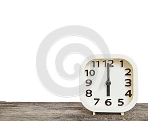 Closeup white clock for decorate in 6 o`clock on old brown wood desk isolated on white background with copy space