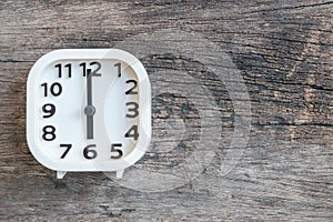 Closeup white clock for decorate in 6 o`clock on old wood floor textured background with copy space