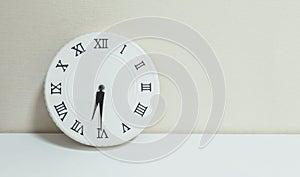 Closeup white clock for decorate show half past six or 6:30 a.m. on white wood desk and cream wallpaper textured background with c photo