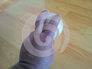 Closeup and of a white cricket hard ball in hands