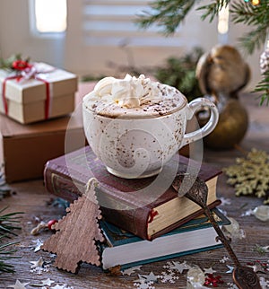Closeup white cup of coffee on the festive table and gift boxes on wooden background. Christmas or New Year