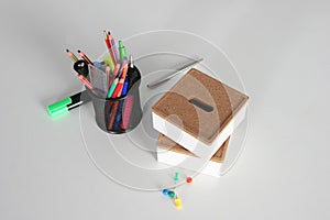 Closeup of white desktop with laptop, glasses, coffee cup, notepads and other items on blurry city background