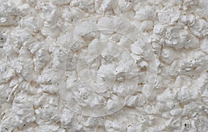 A closeup of white foam on beige flooring, resembling limestone texture