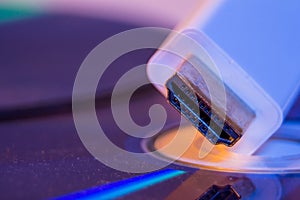 Closeup of white HDMI cable with it`s reflection on blank disc