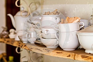 Closeup of white plates and dinnerware in a cupboard