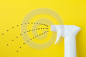Closeup of white spray  bottle on yellow background with spraying line from black saseme seeds, Spraying water or planting concept