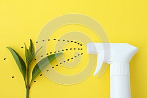 Closeup of white spray  bottle on yellow background with spraying line from black saseme seeds to baby plant, Spraying water or