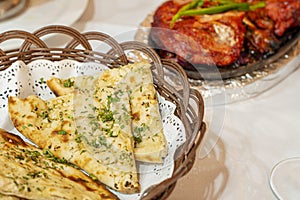 Closeup of wicker basket with sliced garlic bread on the table of a hindu restaurant